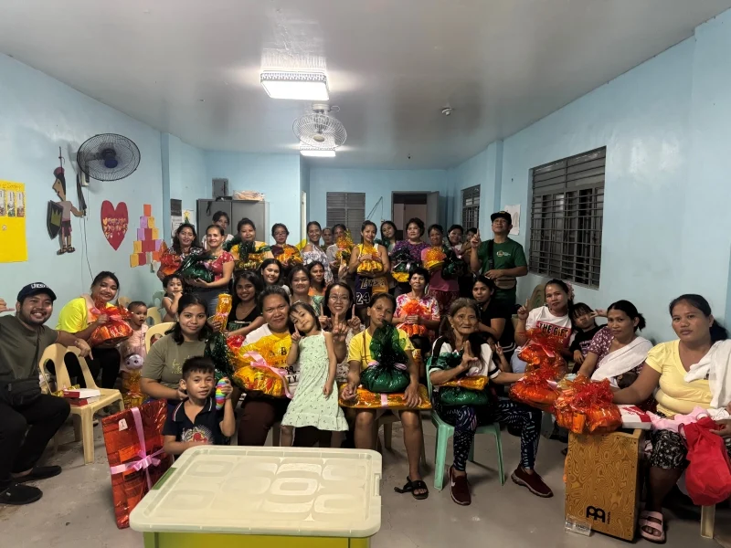 Mothers and children gathered in a bright classroom with gift bags