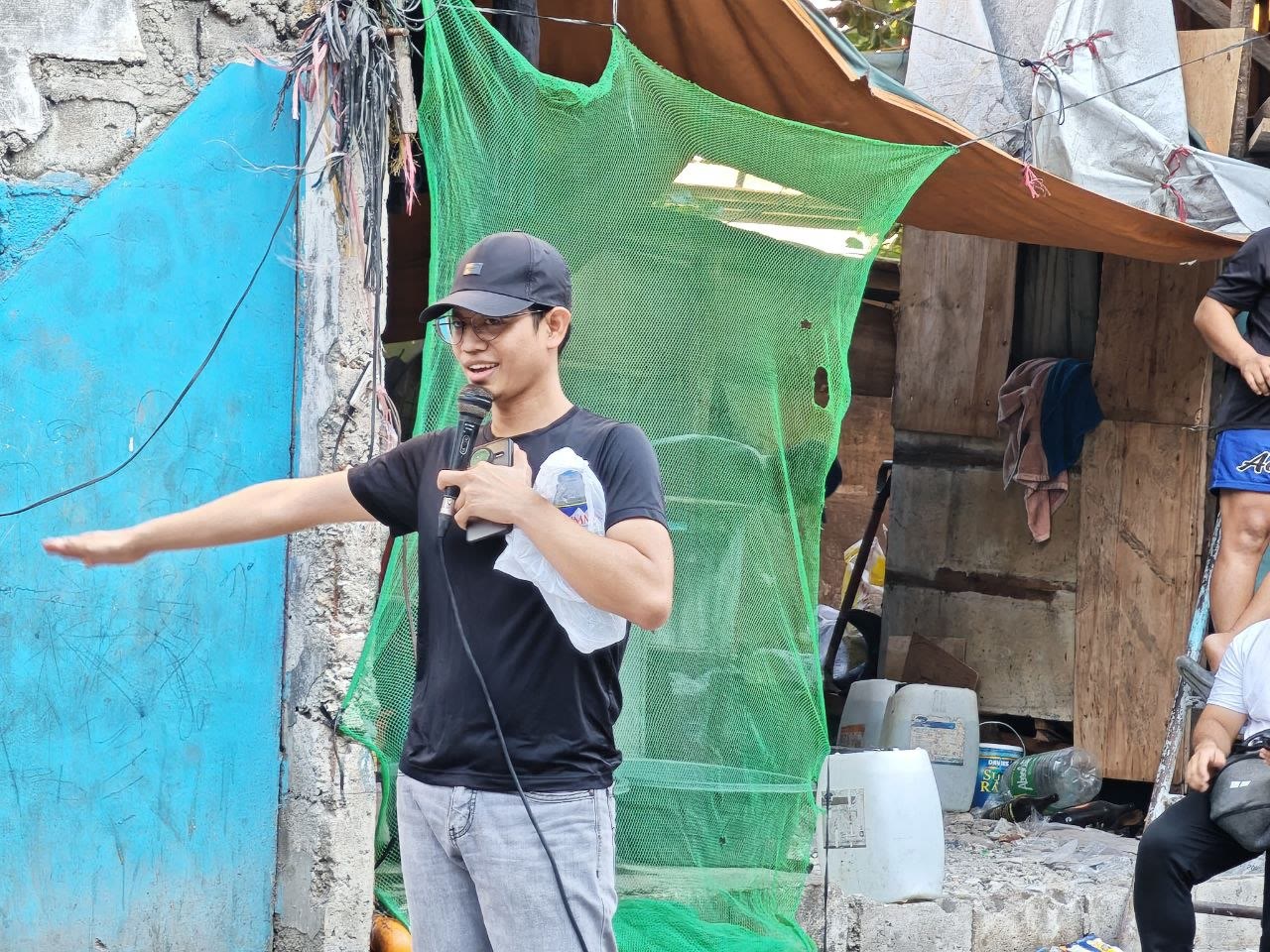 Arise Ministry member preaching during a community outreach in Tondo